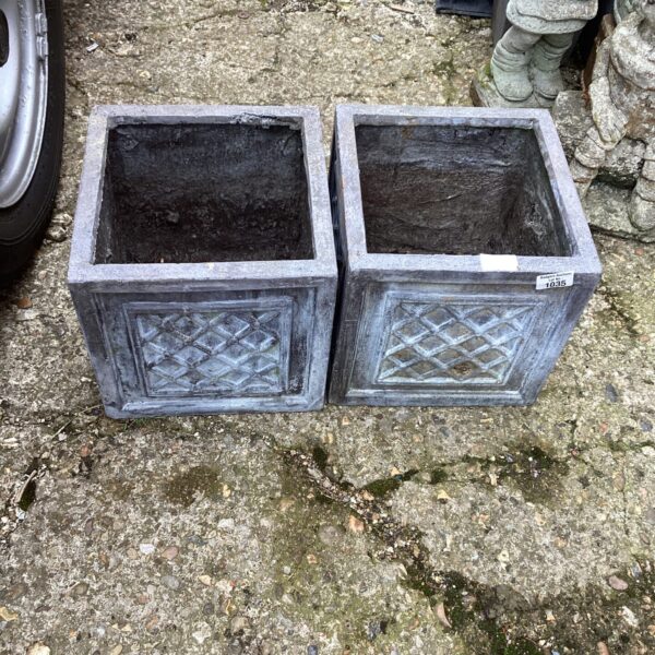 Two square stone effect garden planters for outdoor use.