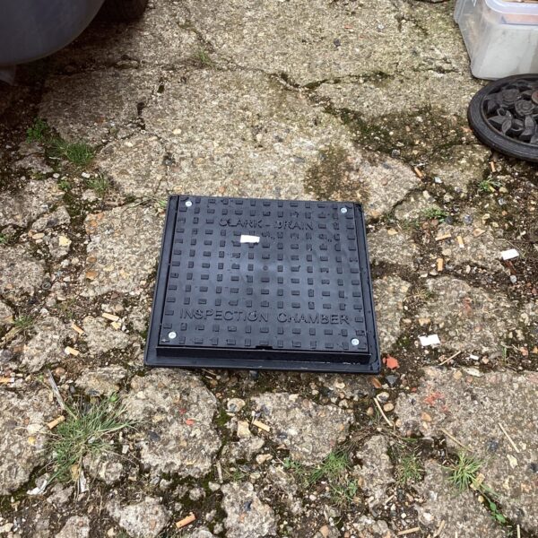 Heavy-duty drain inspection chamber cover for underground access.