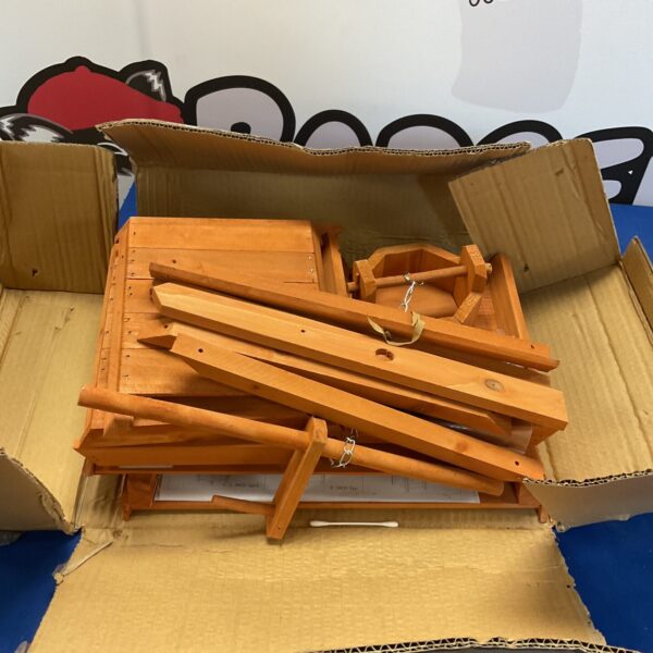 Unassembled wooden wishing well kit for garden decoration.