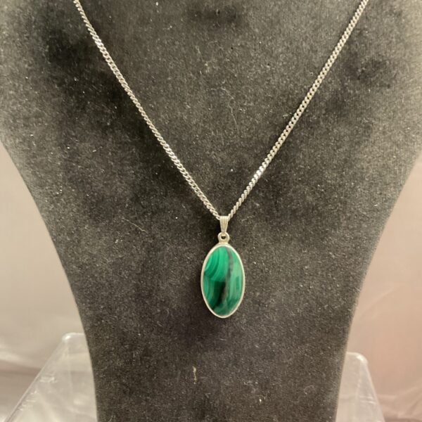 Silver chain necklace with oval malachite pendant.