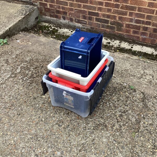Stack of colourful plastic storage boxes for household organisation.