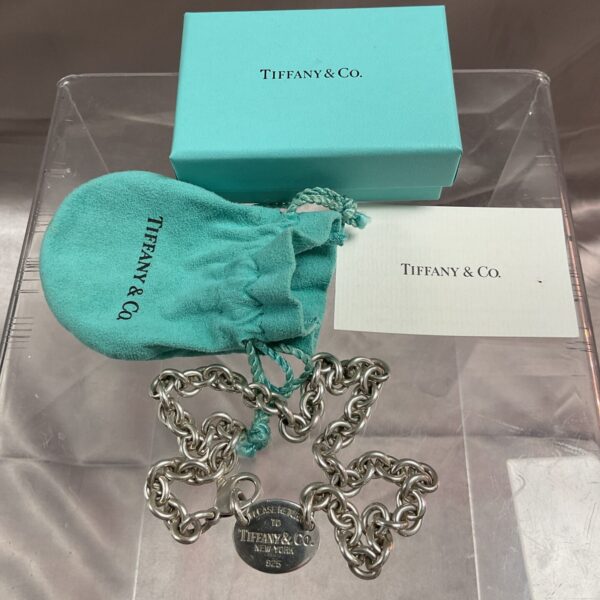 Tiffany & Co. silver choker necklace displayed with box and bag.