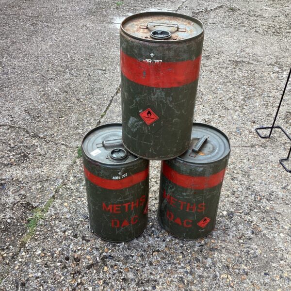Lot of three vintage metal oil drums showing wear and tear.