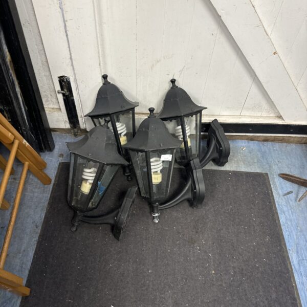 Four vintage outdoor lantern wall lights with dark metal frames.