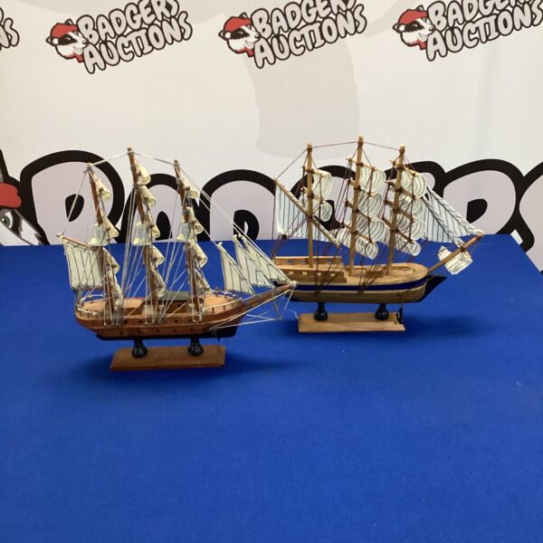 Pair of vintage wooden model sailboats for nautical display.
