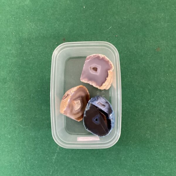 Close-up of a lot of three small geodes with crystal formations.