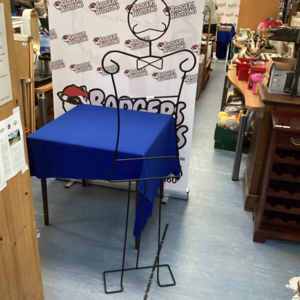 Vintage metal clothes hanger display with blue fabric.