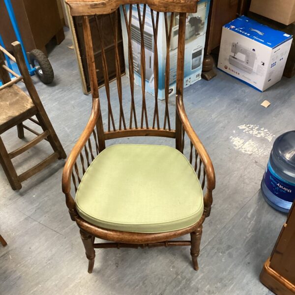 Antique stick back chair with green upholstery, vintage farmhouse style.