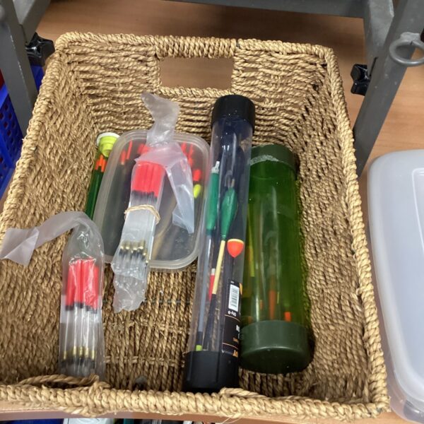 Assorted fishing floats in a clear plastic tube for storage.