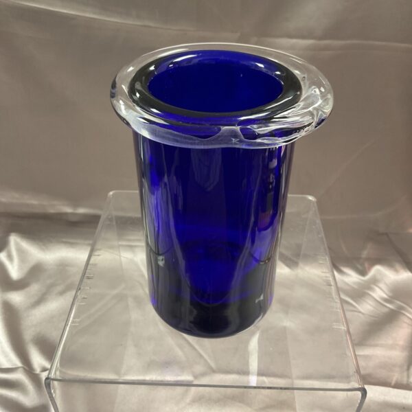 Signed Roubic kova blue art glass vase on display.