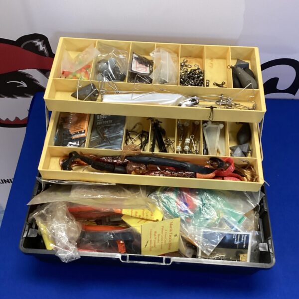 Assorted fishing tackle in a plastic box, including lures and weights.