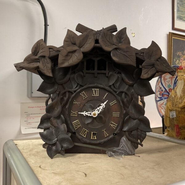 Dark carved Victorian cuckoo clock with intricate details.