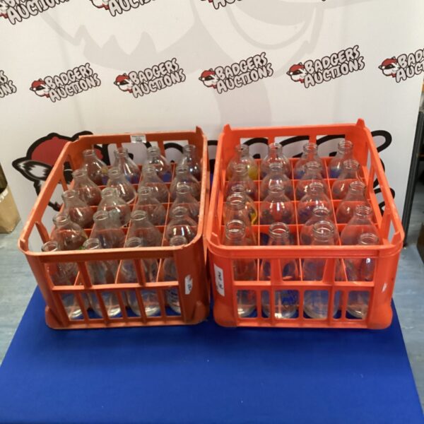 Two crates filled with collectible vintage glass milk bottles.