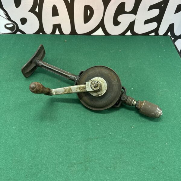 Side view of a vintage brace drill with wooden handle.