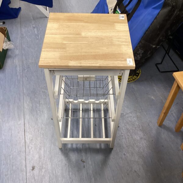 White metal kitchen stool with tiered vegetable rack for storage.