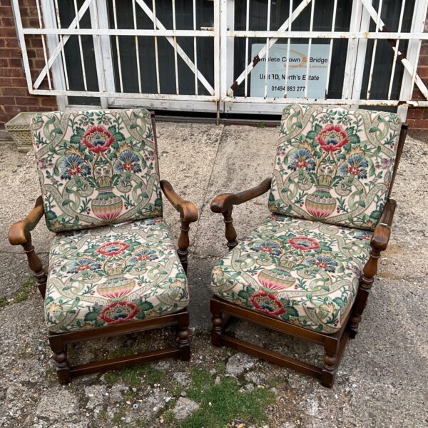 Pair of vintage Ercol armchairs with patterned upholstery.