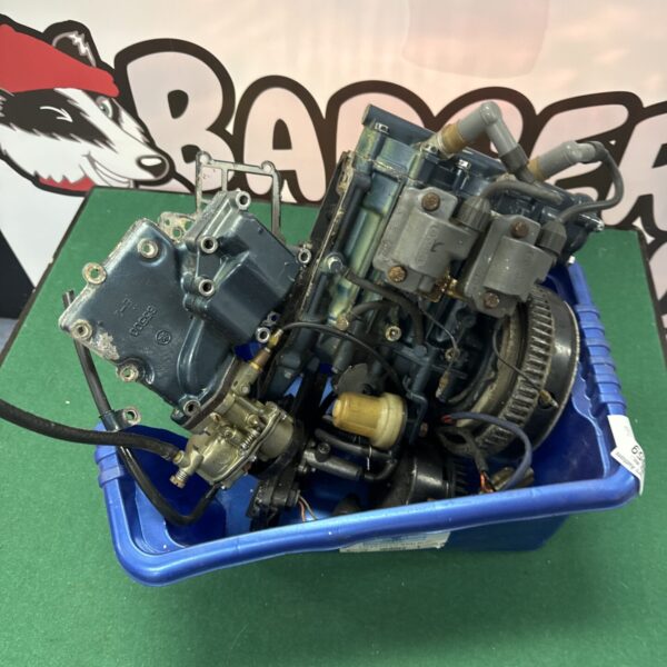 Vintage two-stroke engine drive unit with carburetor visible.