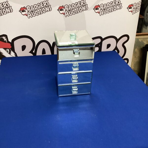 Side view of a vintage mirrored jewellery box with four drawers.