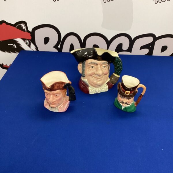 Close-up of three vintage Toby Jugs with detailed faces.