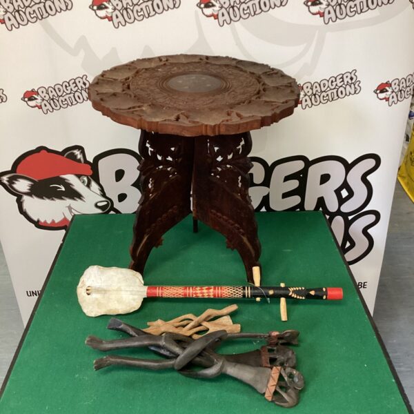 Intricately carved Indian folding table with turtle shell instrument.