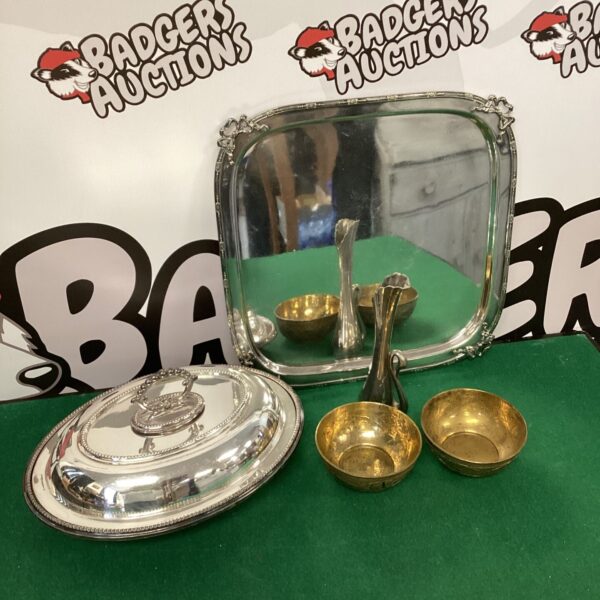 Vintage silver plate serving set with Indian brass bowls displayed on a patterned surface.