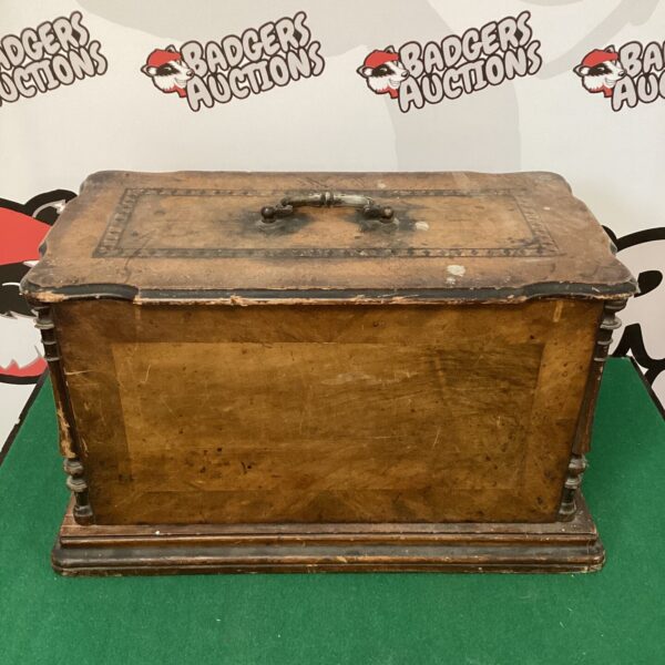 Antique wooden sewing machine box with lock and handle.