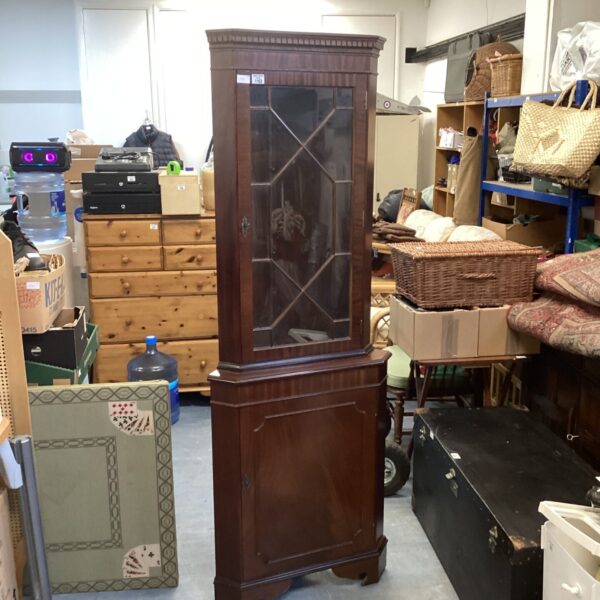 Vintage dark wood corner cabinet for display and storage.