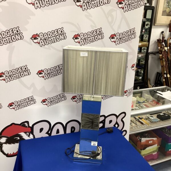 Vintage Art Deco table lamp with geometric design and polished metal finish.
