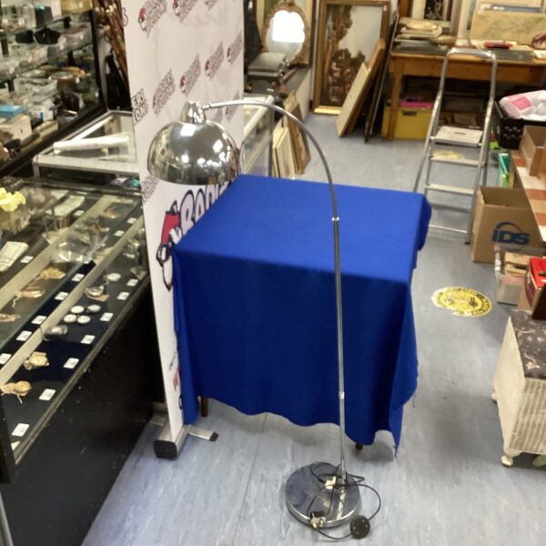 Vintage chrome floor lamp with adjustable head and weighted base.