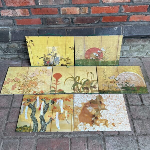 Set of seven framed oriental floral prints on a wall.