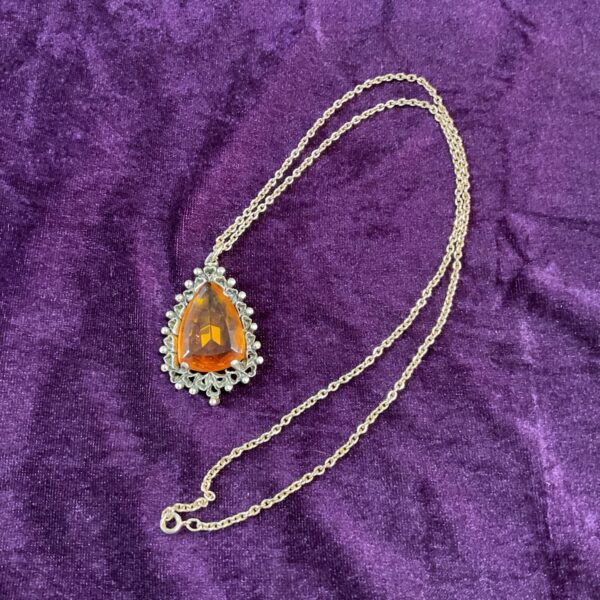 Vintage amber pendant necklace on a gold tone chain.