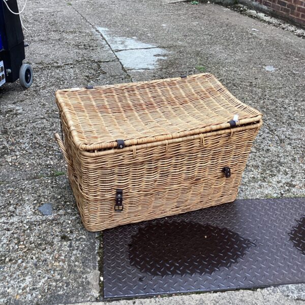 Large wicker basket with hinged lid for storage.