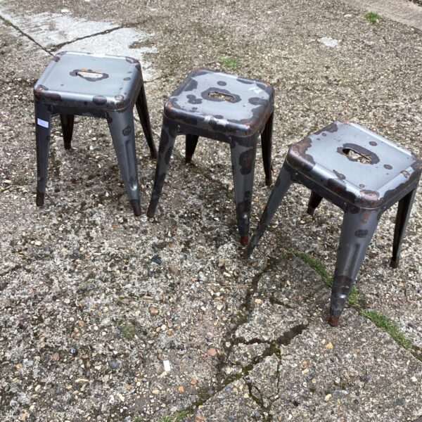 Lot of three vintage metal stools with industrial aesthetic.