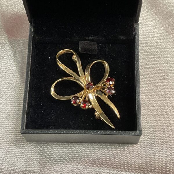 Vintage 9ct gold brooch with ruby accents, elegant jewellery.