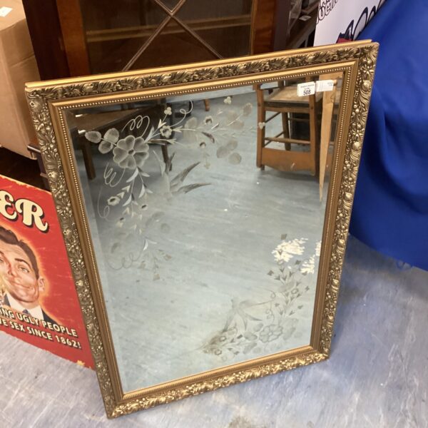Large gilt framed mirror with floral inlay, vintage wall decor.