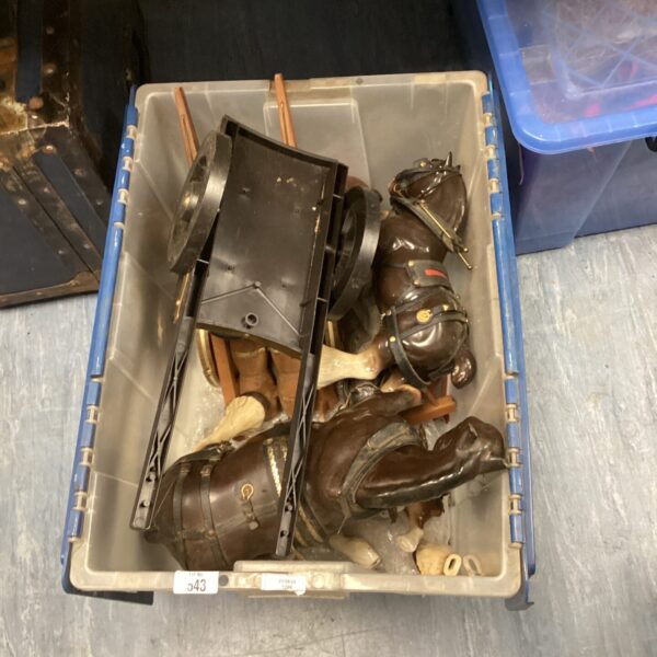 Vintage horse and cart ornaments in a blue storage box.