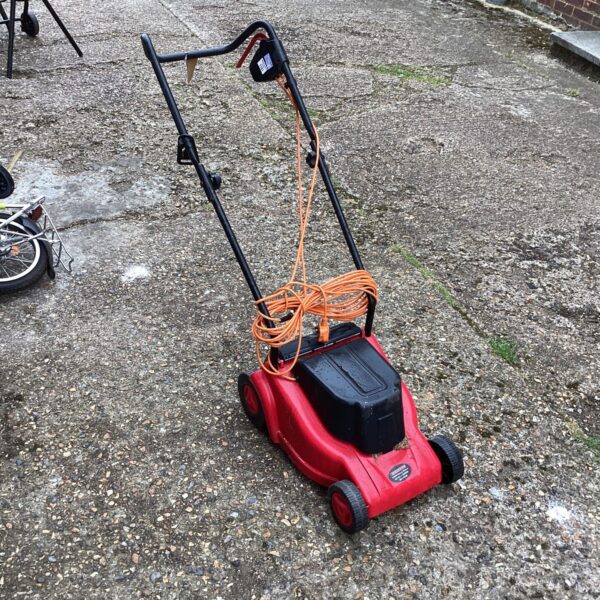 Electric Champion lawn mower in a garden setting.