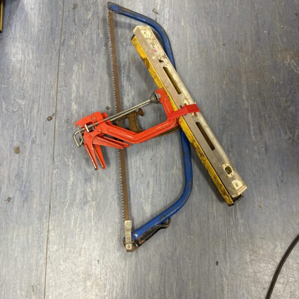 Vintage wood saw and clamp set with spirit levels for woodworking.