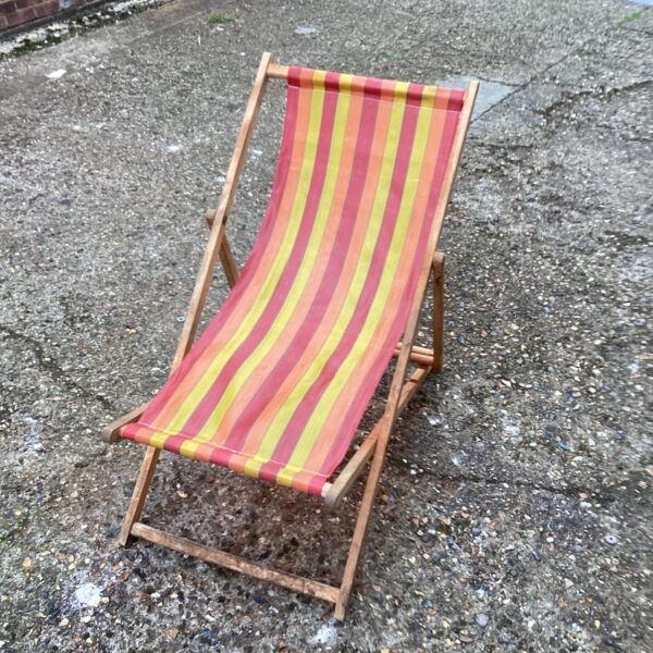 Colourful vintage striped deck chair for garden or beach use.