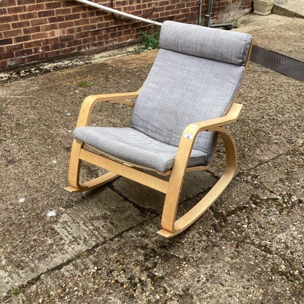 Grey upholstered modern rocking chair with wooden frame.