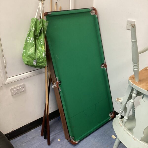 Green snooker table with balls and cues, tabletop billiards.