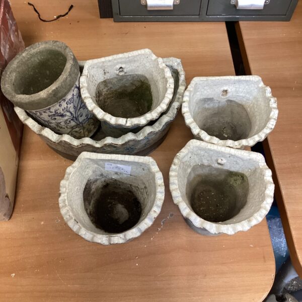 Lot of five vintage ceramic wall pots with floral designs.