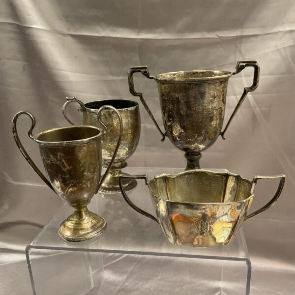 Lot of four antique silver trophy cups with engraved details.