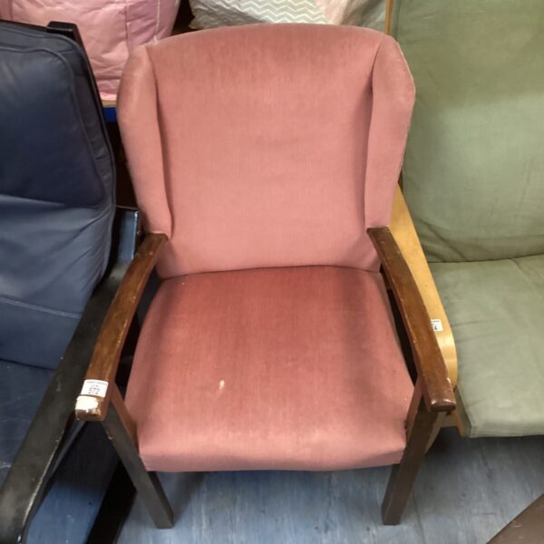 Vintage pink armchair with wooden legs, mid-century style.