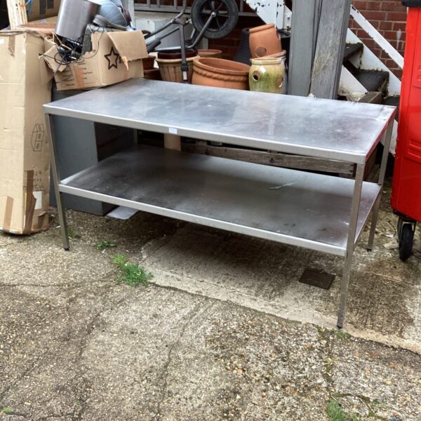 Large stainless steel industrial table with a metal surface.