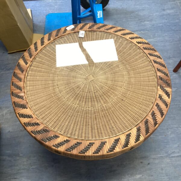 Circular wicker glass top table with detailed rattan weave.