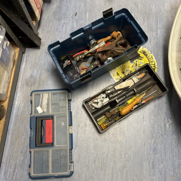 Vintage plastic toolbox filled with a set of hand tools.