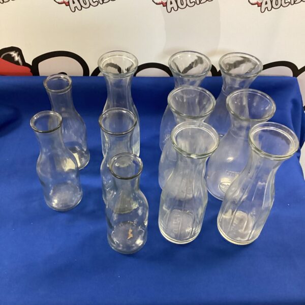 Assortment of eleven clear glass vases for home decor.