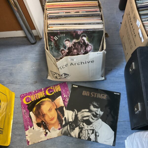 Mixed lot of vintage vinyl records in a cardboard box.