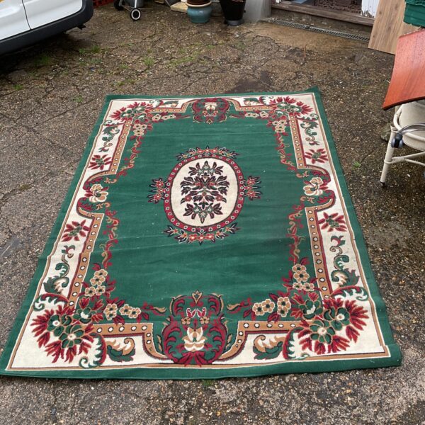 Large green Persian style rug with intricate pattern.